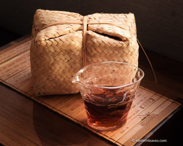 Tianjian cha dark black tea, fermented, in original bamboo leaf basket; 2014 harvest from China in glass server